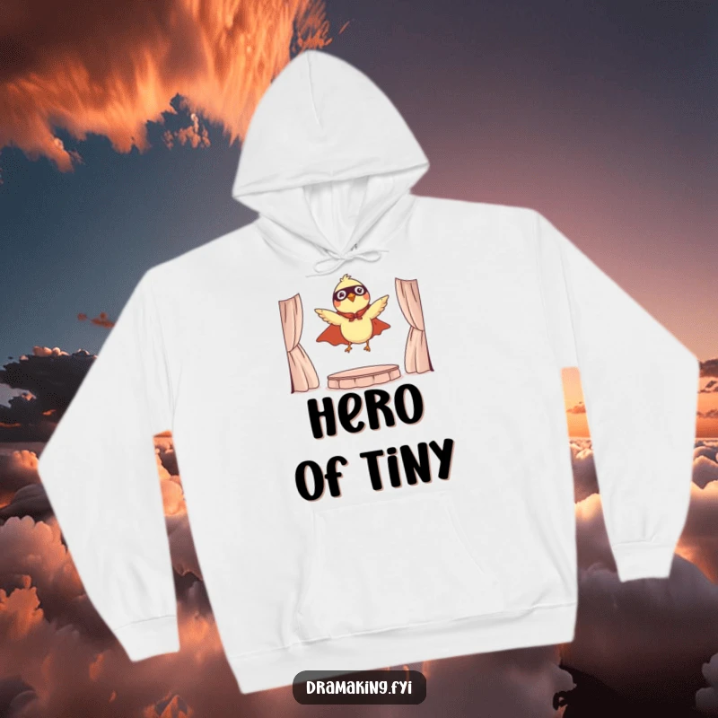 Funny hoodie featuring a tiny bird in a cape, dramatically leaping from a miniature stage, inspiring bravery.