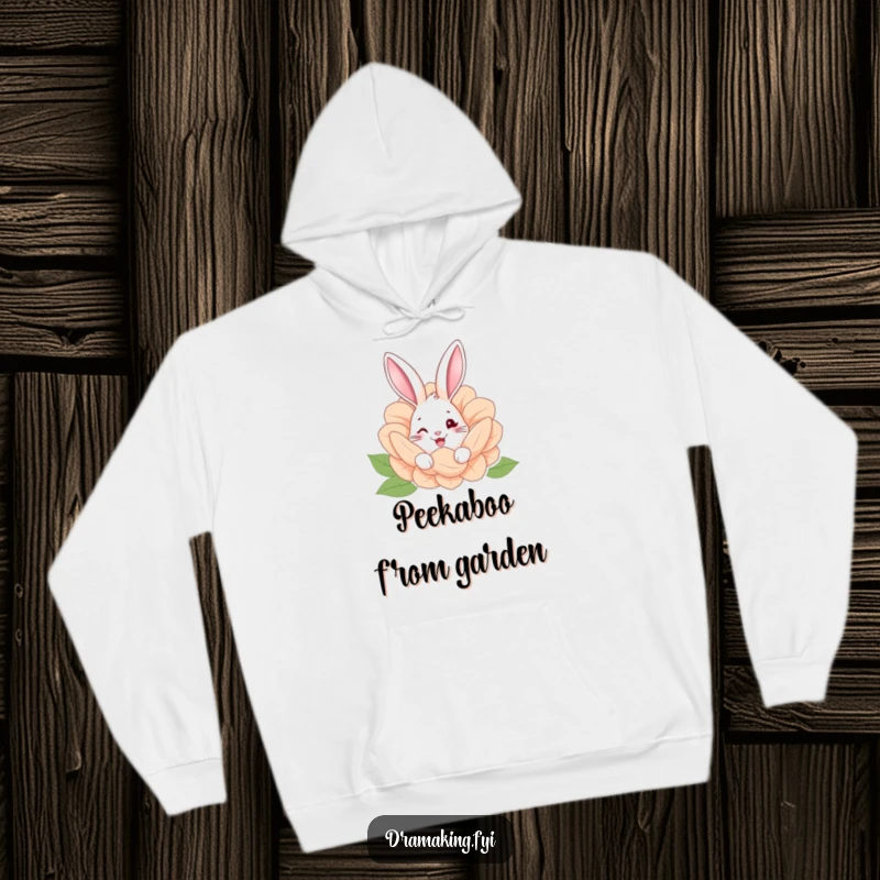 Funny hoodie featuring a happy rabbit with a twinkle, peeking from behind a giant flower, evoking garden wonder.