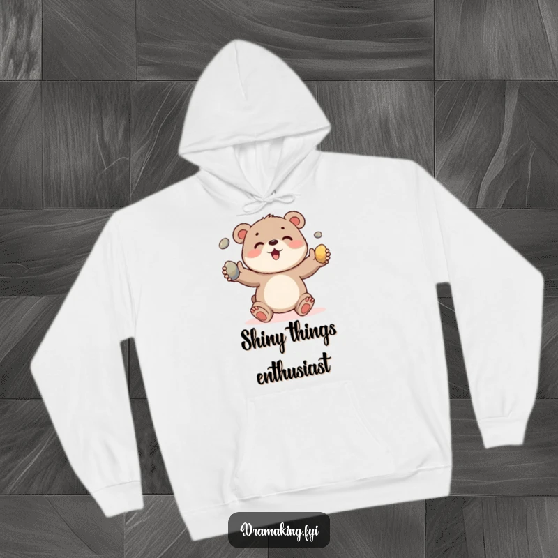 Funny hoodie showcasing a cheerful bear cub juggling three shiny pebbles, perfect for cozy, humorous wear.